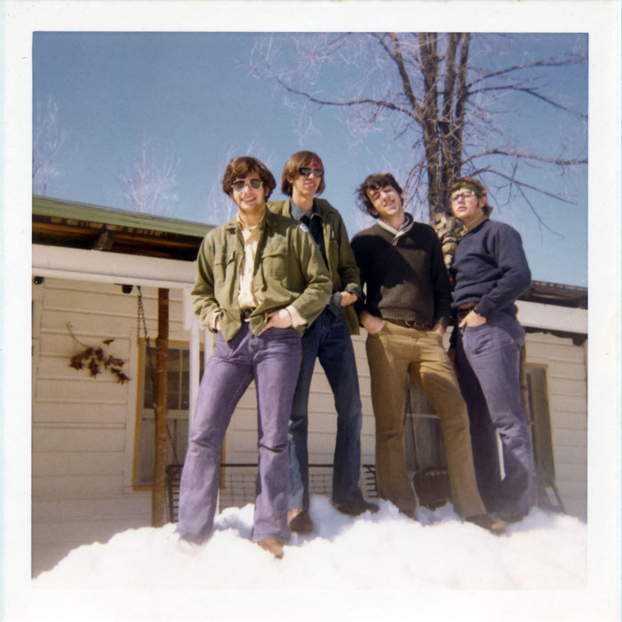 Posing on a mound of snow in front of the cabin